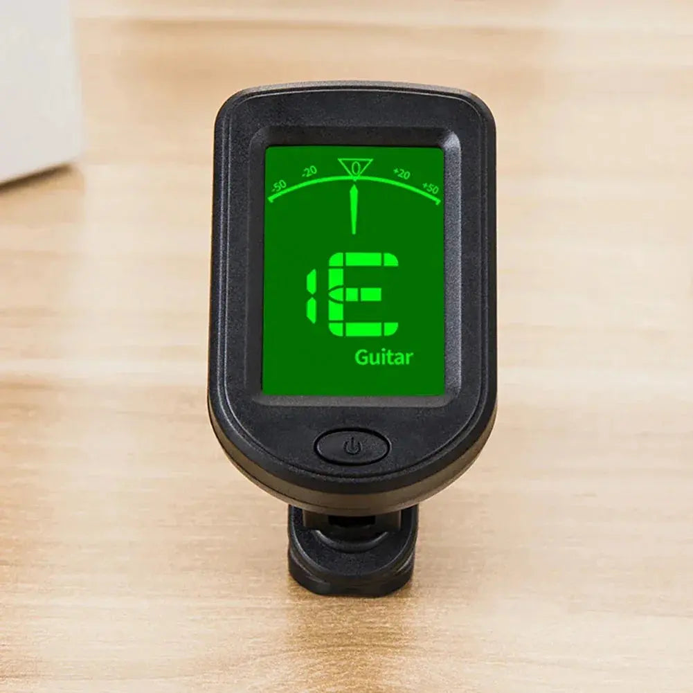 Clip-on digital guitar tuner with green display on wooden surface