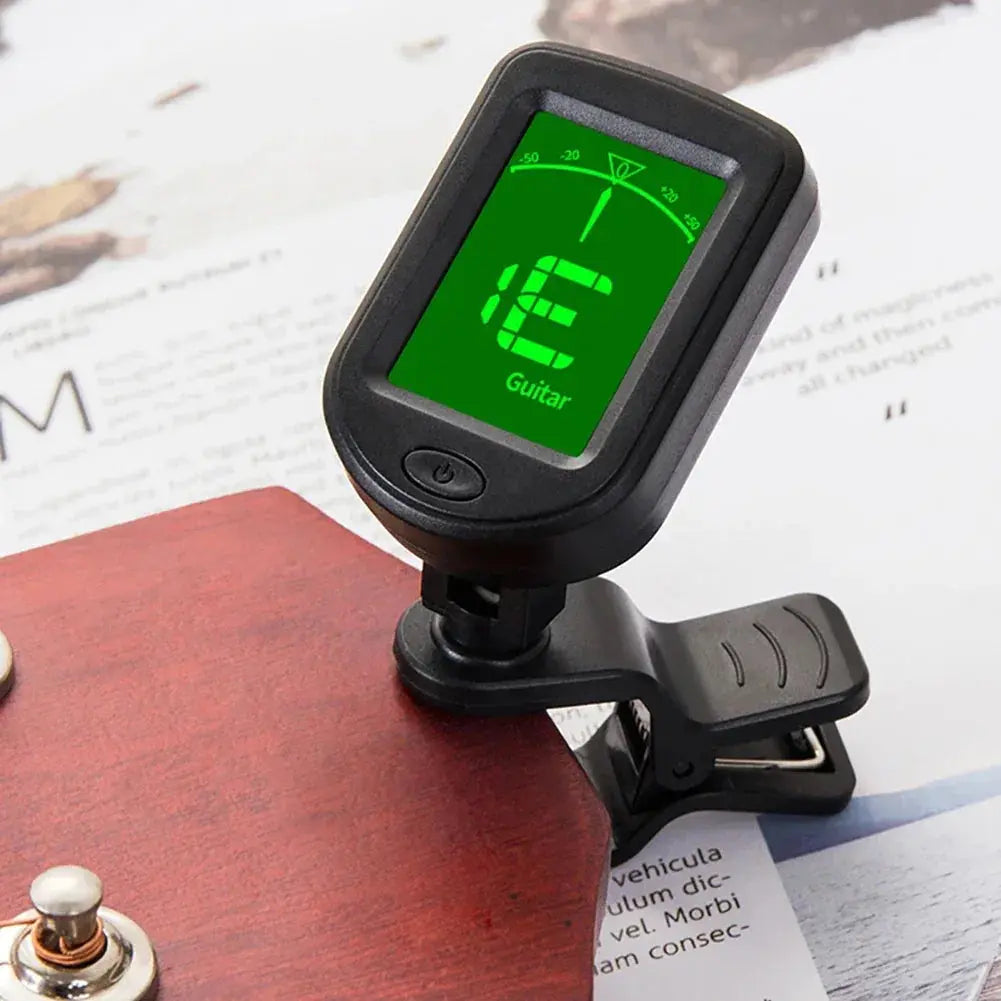 Clip-on digital guitar tuner attached to a wooden guitar headstock